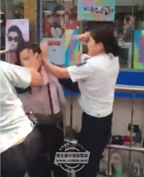 女摊贩紧拽城管大腿